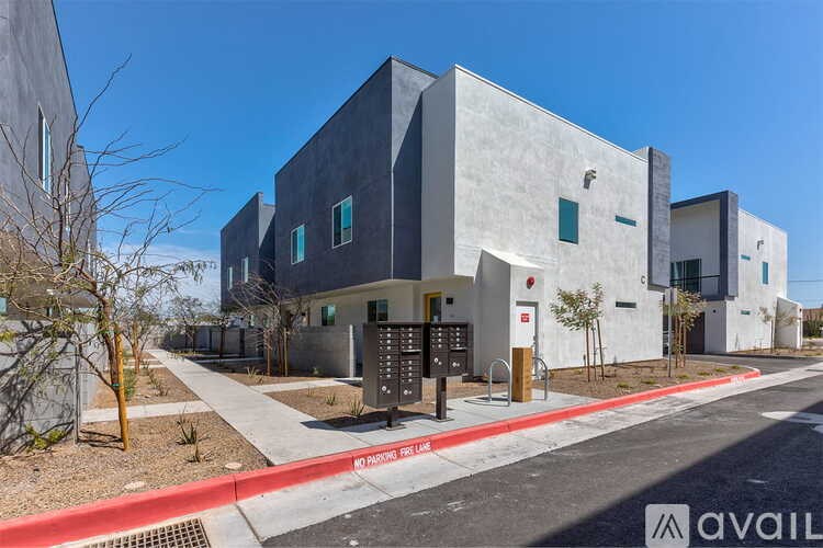 A modern building with a grey exterior and a red line on the sidewalk.