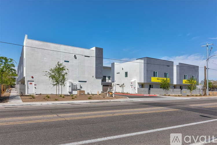 A modern building with a white exterior and a yellow sign on the right side.