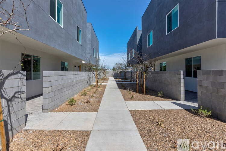 A modern building with a concrete facade and a pathway leading to the entrance.