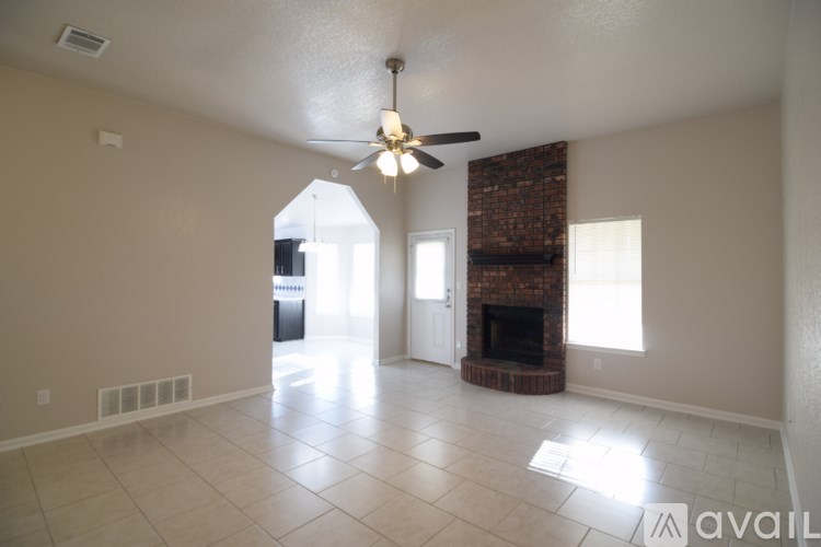 A living room with a fireplace and a ceiling fan.