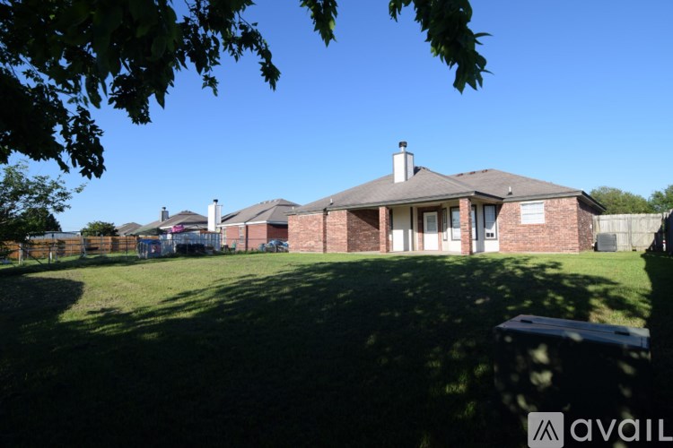 A house with a large lawn and a tree in the foreground.
