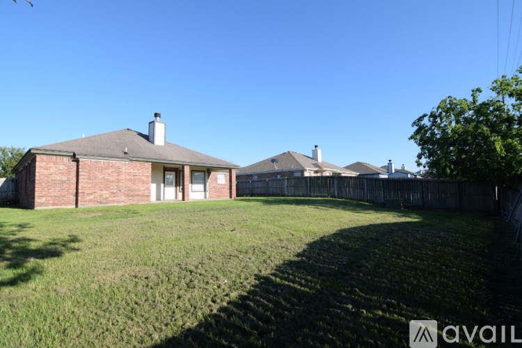 A house with a fence and a tree in front.
