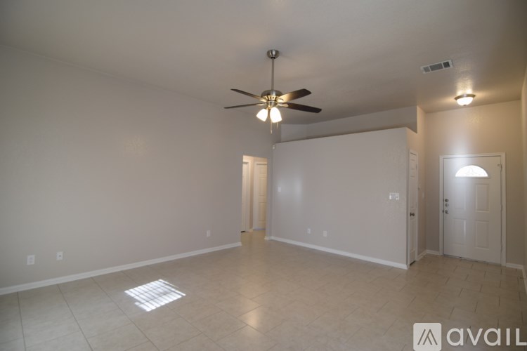 A spacious room with a ceiling fan and two doors.
