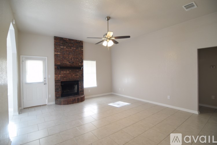 A living room with a fireplace and a ceiling fan.