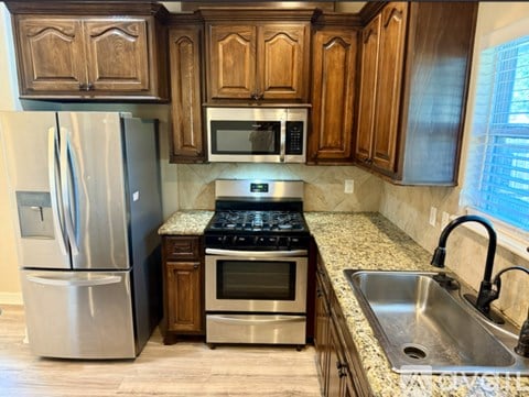 A kitchen with wooden cabinets and stainless steel appliances.