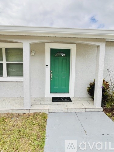 A white house with a green door and a small front yard.