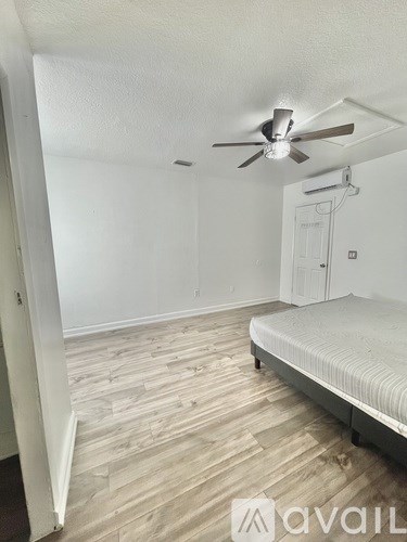 A room with a bed and a ceiling fan.