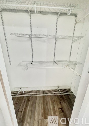 Empty white shelves in a room with wooden floors.