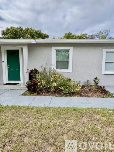 A house with a green door and a small garden in front.