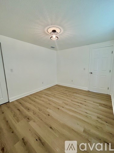 A room with wooden flooring and a ceiling light.