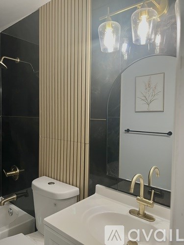 A bathroom with a toilet, sink, and a mirror.