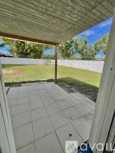 A patio with a tiled floor and a white wall.