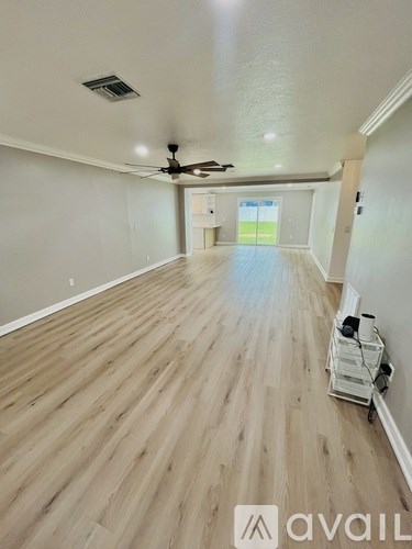 A room with wooden flooring and a ceiling fan.