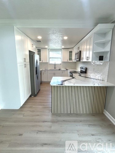 A kitchen with a white countertop and wooden cabinets.
