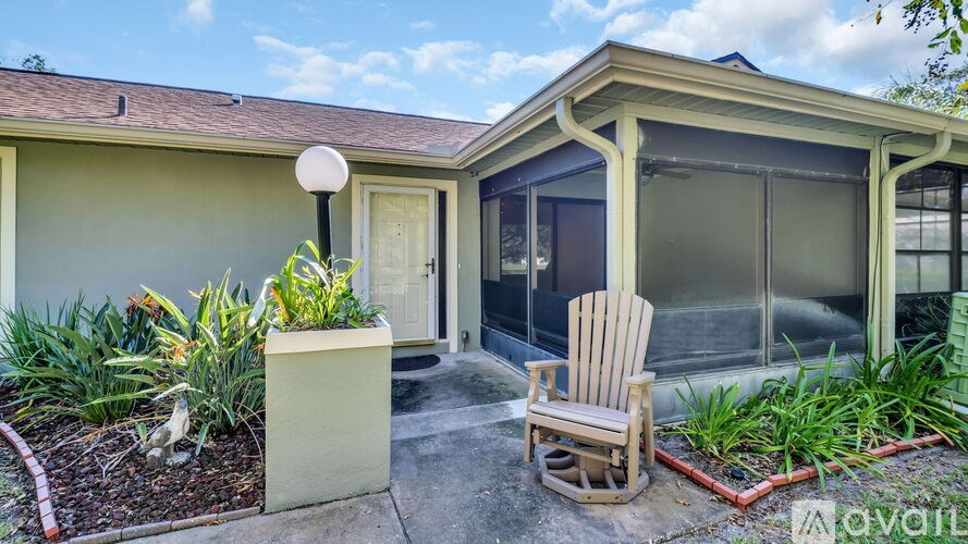 A house with a patio and a chair is for sale.