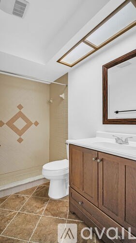 A bathroom with a toilet, sink and brown tiles.