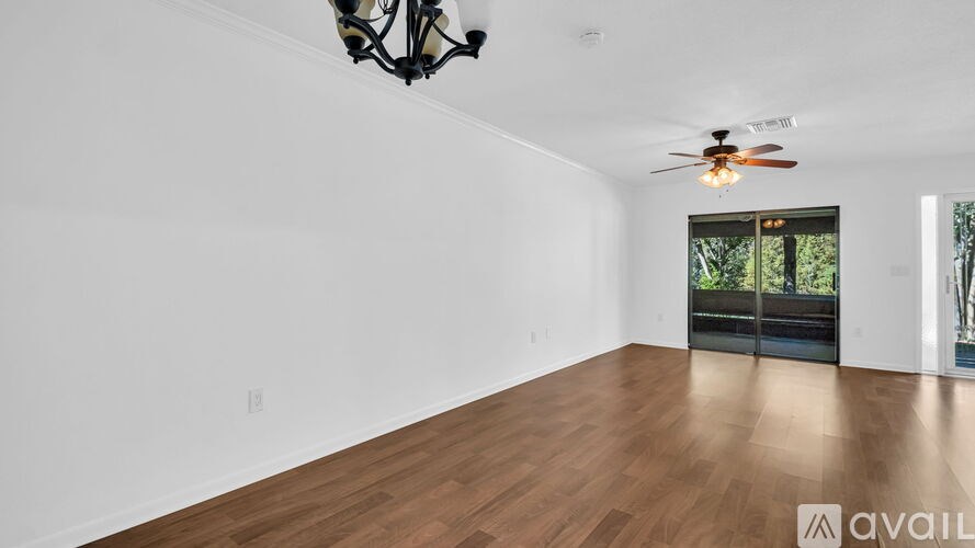 A room with wooden floors and a ceiling fan.