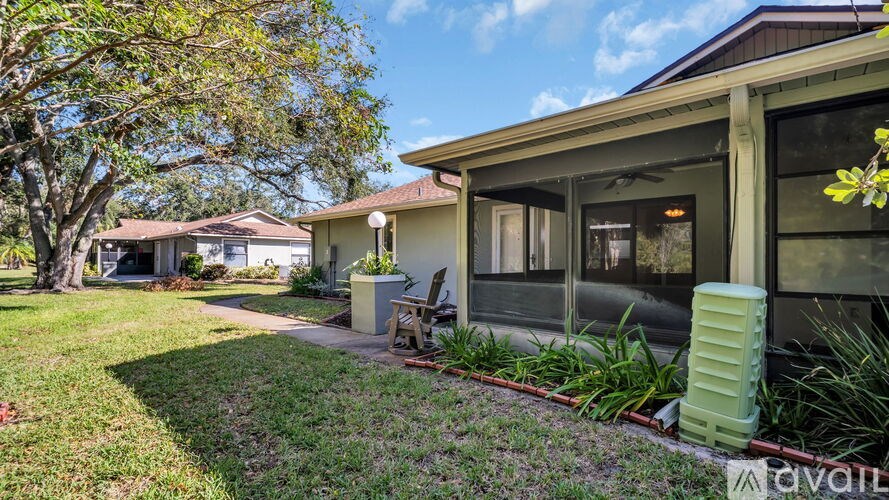 A house with a lawn and a tree in front of it.