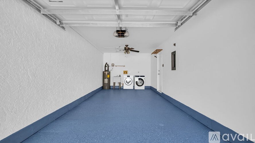 A long hallway with a blue floor and white walls.