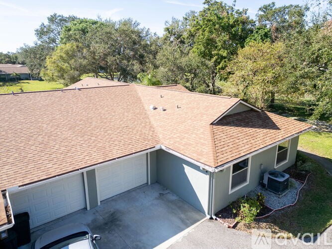A house with a brown roof and a grey garage door.