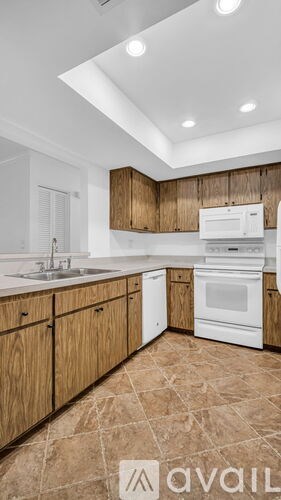 A kitchen with wooden cabinets and white appliances.