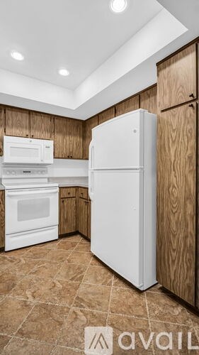 A kitchen with a white refrigerator, microwave, and oven.