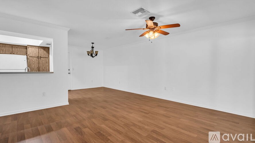 A room with wooden flooring and a ceiling fan.