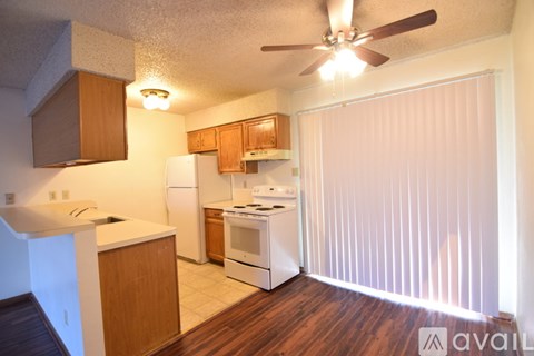 A kitchen with wooden cabinets and a white refrigerator.