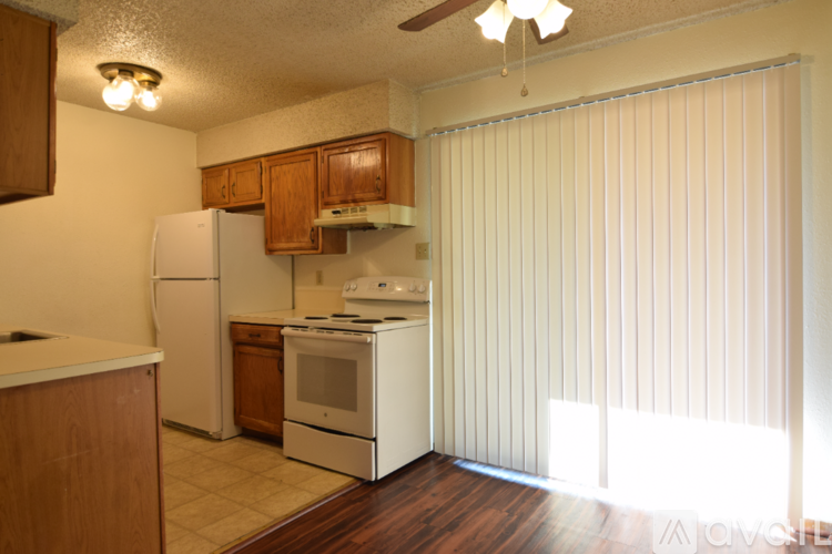 A room with wooden floors and a white wall with a door.
