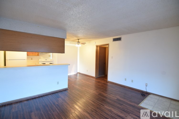 A room with wooden floors and a white wall with a door.