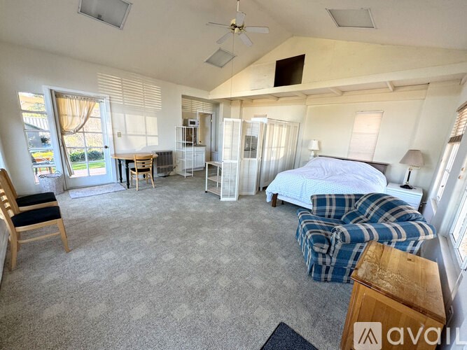 A bedroom with a bed, chair, and table.