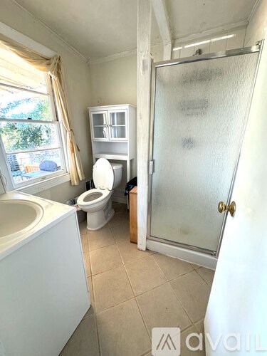A bathroom with a toilet, sink, and shower.