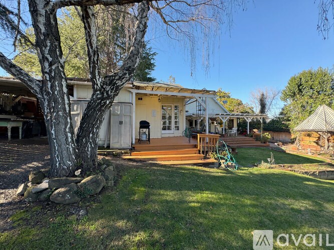 A house with a porch and a tree in front.