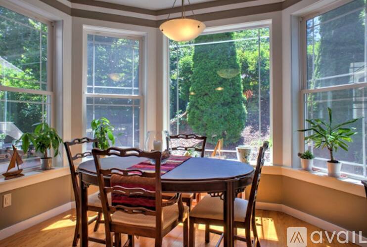 A dining room with a table and chairs and a window.