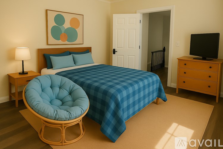 A bedroom with a bed, a chair, a nightstand, and a television.