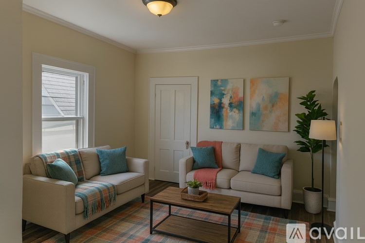 A living room with a couch, a coffee table, and a painting on the wall.