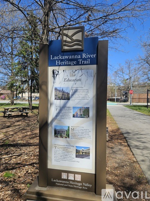 A sign for the Lackawanna River Heritage Trail stands in a park.