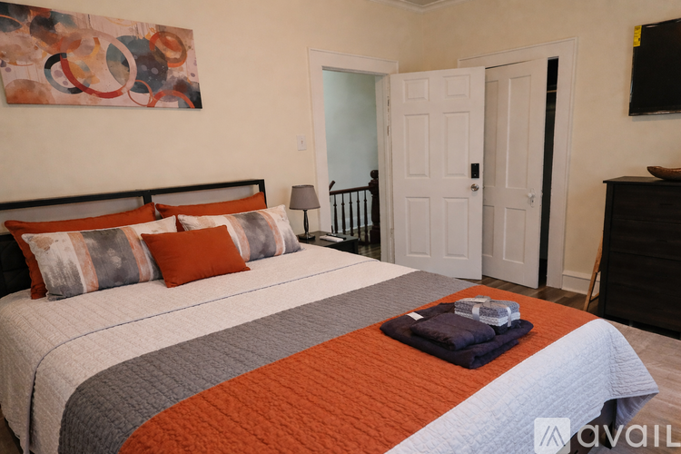 A bedroom with a large bed and a painting on the wall.