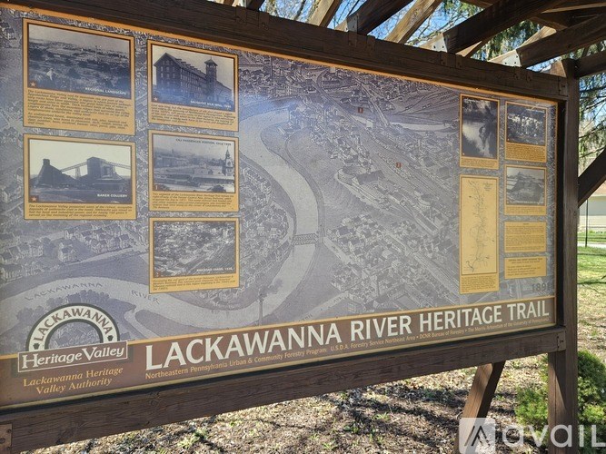 A wooden sign for the Lackawanna River Heritage Trail is displayed outdoors.