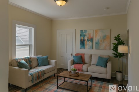 A living room with a couch, a coffee table, and a painting on the wall.
