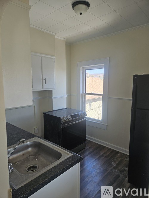 A kitchen with black appliances and a window.