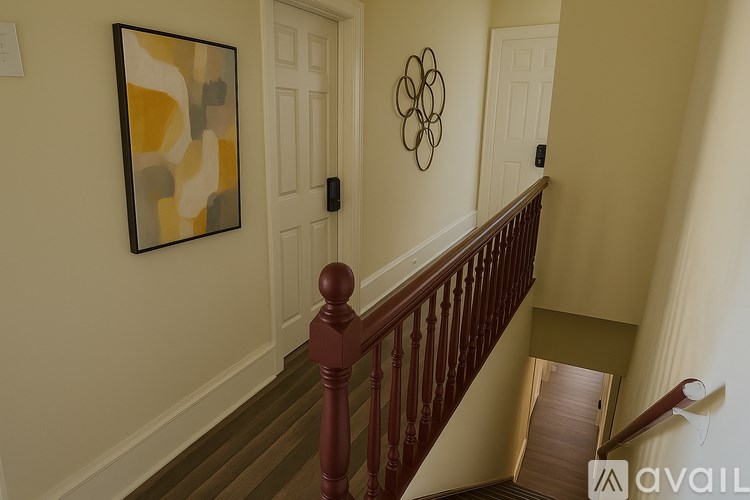 A staircase with a wooden banister and a painting on the wall.