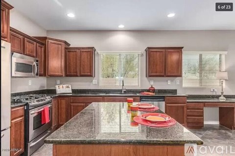 A kitchen with granite countertops and wooden cabinets.
