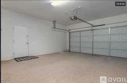 A spacious garage with a white door and a wall of windows.