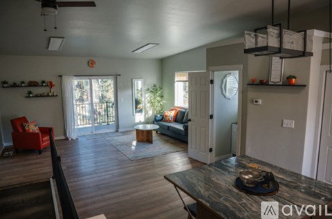 A living room with a red chair and a black hat on the table.