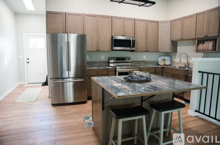 A kitchen with a table and chairs in front of it.