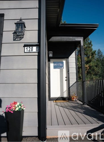 A house numbered 128 B with a porch and a flower pot.