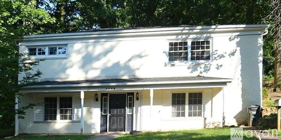 A white house with a black roof and a black door.