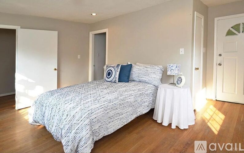 A room with wooden floors and two windows.