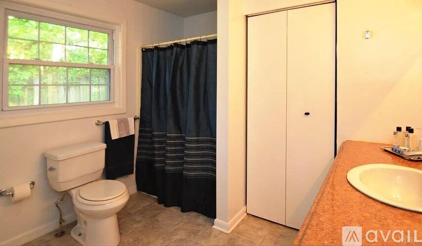 A bathroom with a toilet, sink, and shower.